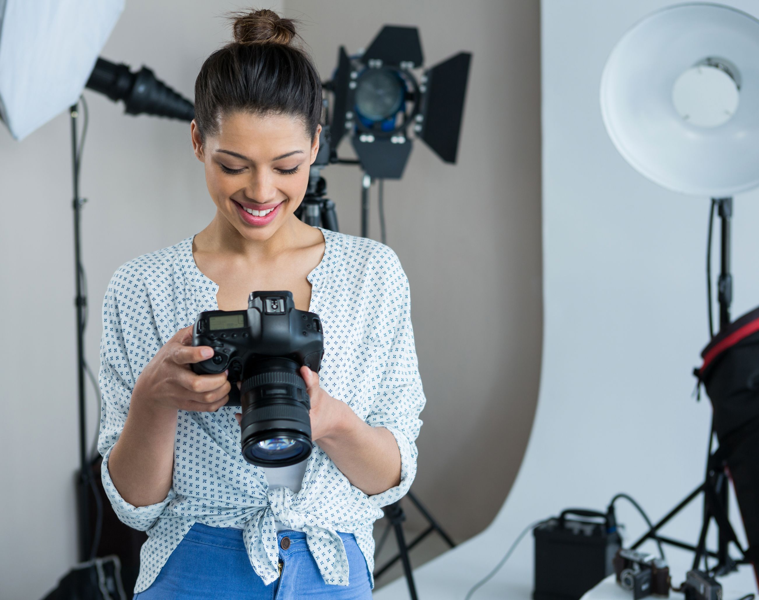 VKTWA Woman smiling, holding camera in photography studio.